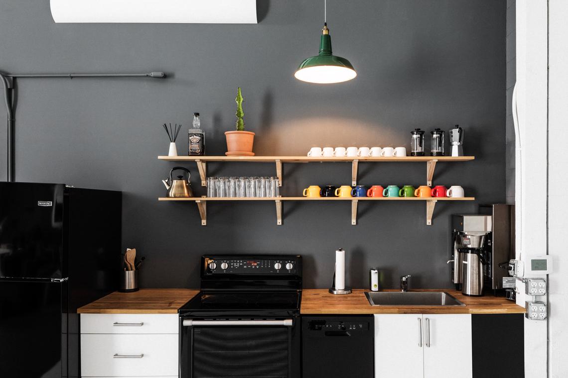 The kitchen — full range, espresso machine, and a shelf of mugs