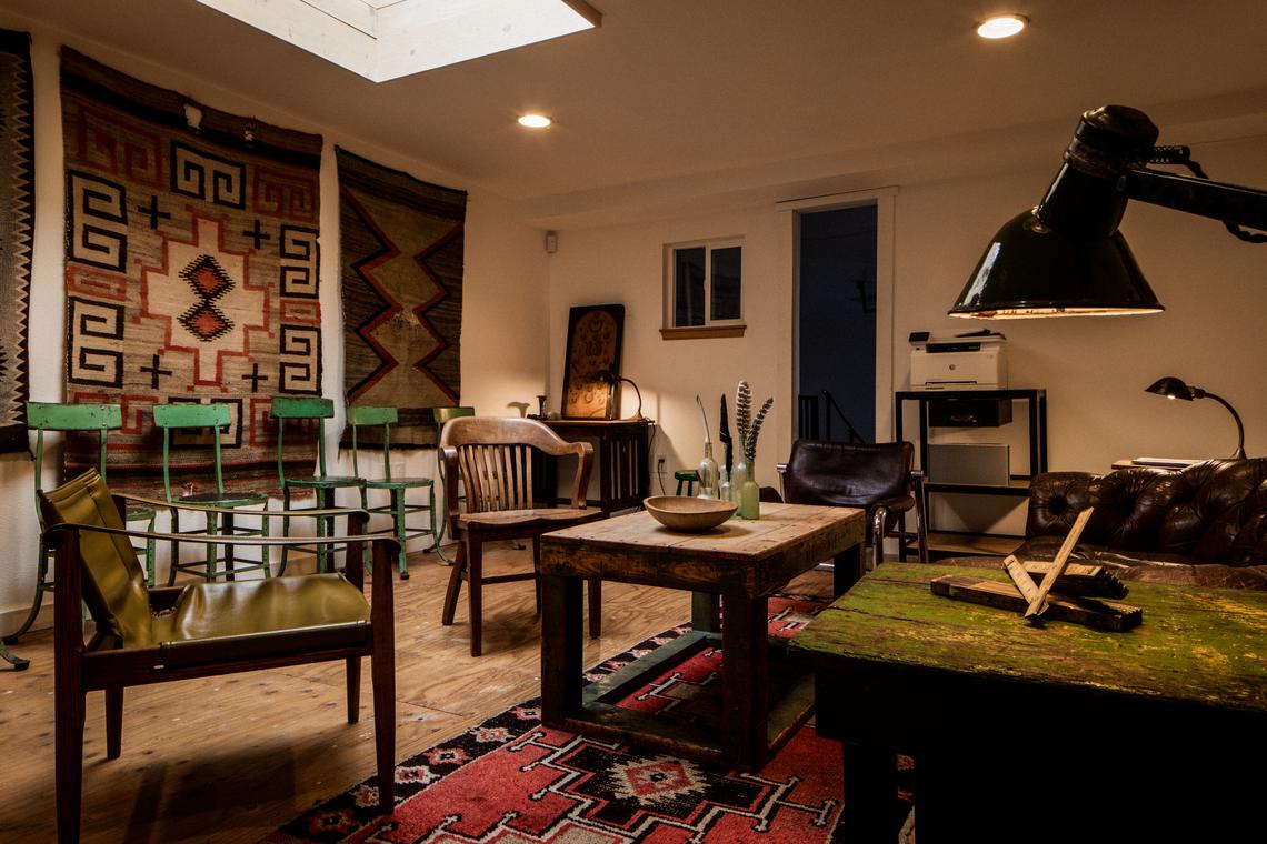 The downstairs lounge — vintage rugs, leather chairs, and work lamps