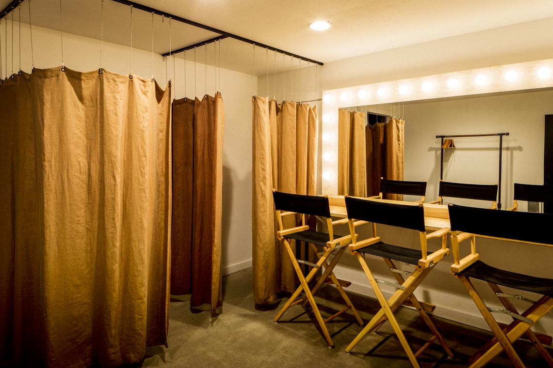 Dressing area with gold curtains and director's chairs